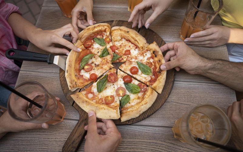 close-up-hands-holding-pizza-slices